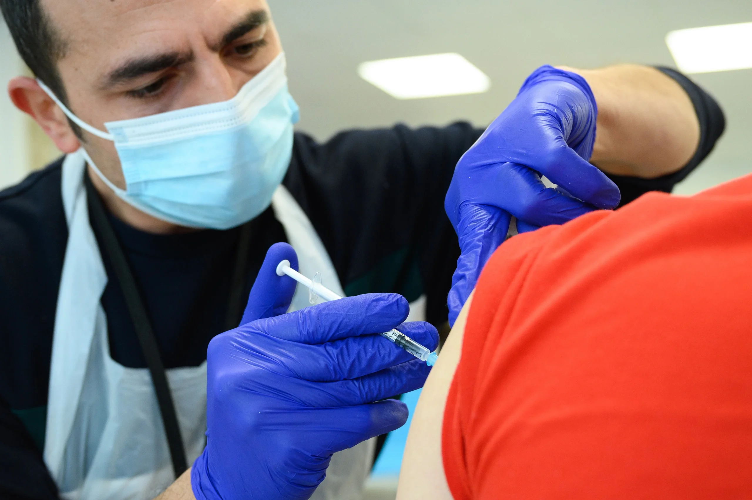 Scientists administering the Marburg virus vaccine to a volunteer during human trials.