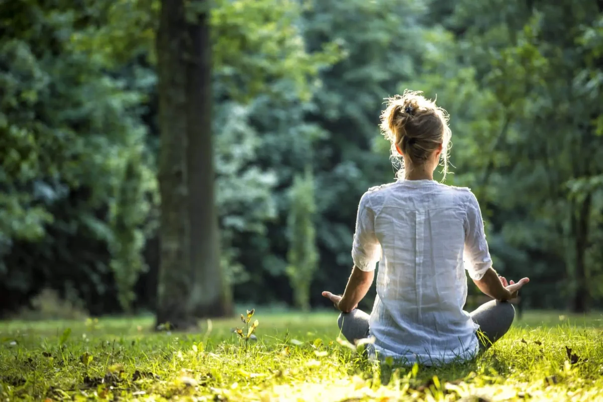 A peaceful person meditating in nature to recover from mental tiredness